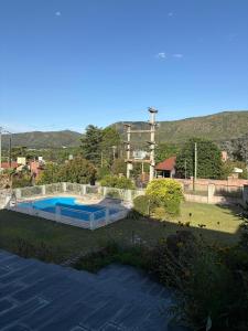 ein Schwimmbad in einem Garten mit Bergen im Hintergrund in der Unterkunft Casa de campo Marines in San Antonio de Arredondo + 3 Fotos