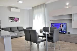 un soggiorno con tavolo, sedie e televisione di Luxury Garibaldi ad Alghero