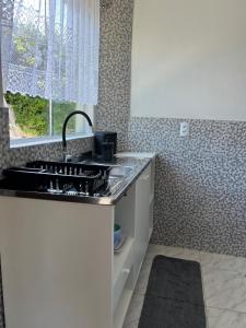 a kitchen with a sink and a counter top at Casinha com área externa in Florianópolis