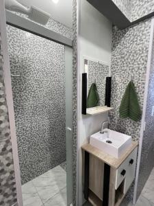 a bathroom with a sink and a shower at Casinha com área externa in Florianópolis