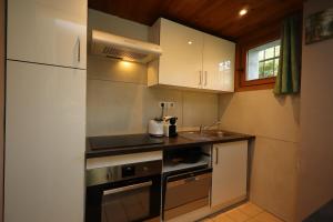 une petite cuisine avec des armoires blanches et un évier dans l'établissement Appartement 2 pers hyper centre Chamonix, à Chamonix-Mont-Blanc