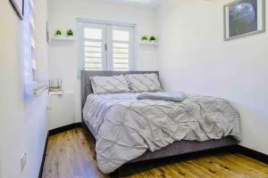 a bedroom with a bed with a gray comforter and a window at Casa Vagon Isla Bendita in La Gonzalez +30 photos
