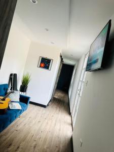 a living room with a blue couch and a flat screen tv at Casa Vagon Isla Bendita in La Gonzalez