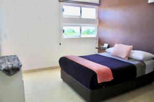 een kleine slaapkamer met een bed en een raam bij CASA LIZ & FER in Zacatlán