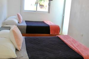 een kamer met drie bedden en een raam bij CASA LIZ & FER in Zacatlán