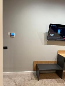 a flat screen tv sitting on a wall at Elmax Aparthotel in Craiova +8 photos