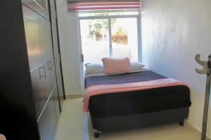 een kleine kamer met een bed en een raam bij CASA LIZ & FER in Zacatlán