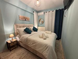 une chambre avec un grand lit aux murs bleus dans l'établissement Kalavryta Moments, à Kalavrita