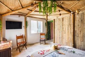 a bedroom with wooden walls and a bed and a tv at Gîtes Mas des rochers - Case bambou avec Spa et piscine in Le Beausset