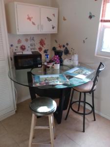 een keuken met een glazen tafel en 2 krukken bij 1 BEDROOM KITCHEn BATHROOM ApT in Titusville