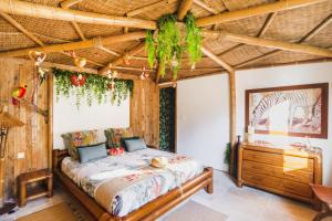 Gîtes Mas des rochers - Case bambou avec Spa في لو بوزيت: غرفة نوم بها سرير وسقف خشبي