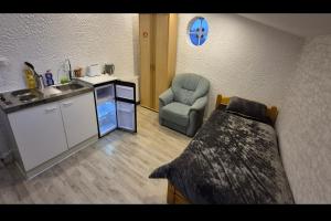 a kitchen with a sink and a chair in a room at Finkenwerder Ferienwohnung Larisa's Nr 23 in Hamburg