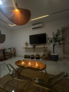 ein Wohnzimmer mit Tisch und Fernseher in der Unterkunft ORY luxury garden in Abidjan