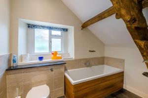 a bathroom with a tub and a toilet and a window at 4 Bed in Malham oc-c32684 in Airton +22 photos