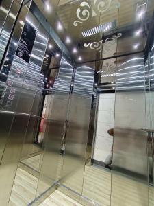 an elevator in a building with a glass wall at Hotel Rukmani Palace in Ujjain