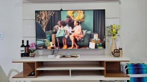 a living room with a tv on a table at Casa Requinte in Cascavel