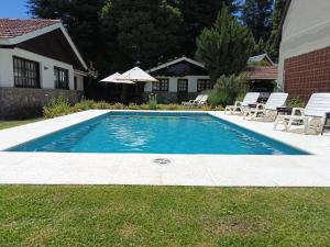 圣马丁德洛斯Apart Rose Garden的院子里有一个游泳池，配有椅子和遮阳伞