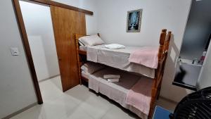 a small room with two bunk beds and a mirror at Casa Requinte in Cascavel