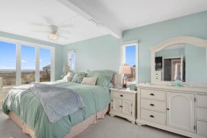 Schlafzimmer mit einem Bett, einem Spiegel und einem Waschbecken in der Unterkunft Island SunRise in Plum Island