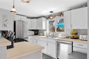 eine Küche mit weißen Schränken und einer Spüle in der Unterkunft Island SunRise in Plum Island