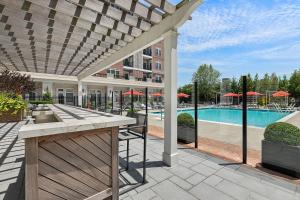an outdoor patio with a pool and a building at Hotel Suites at Vanderbilt in Westbury