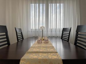 een eettafel met stoelen en een groot raam bij Odmori se, Centar apartman in Donje Mladice