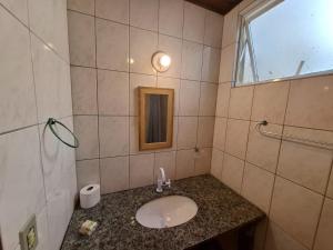 ein Badezimmer mit Waschbecken und Spiegel in der Unterkunft Marina Sul Hotel in Laguna + 16 Fotos