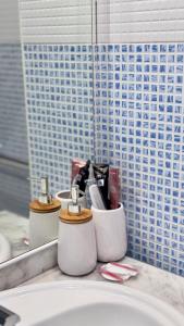 ein Badezimmer mit einem Waschbecken und zwei Seifenspendern in der Unterkunft Amplio apartamento en centro in Denia + 23 Fotos