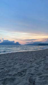 a sandy beach with the ocean in the background at Casinha com área externa in Florianópolis +7 photos