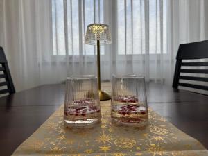 twee glazen zittend op een tafel met een lamp bij Odmori se, Centar apartman in Donje Mladice +6 foto's