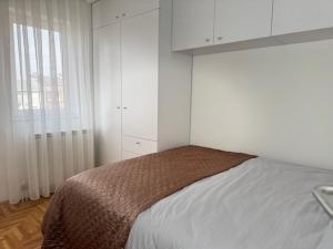 een slaapkamer met een bed met witte kasten en een raam bij Odmori se, Centar apartman in Donje Mladice