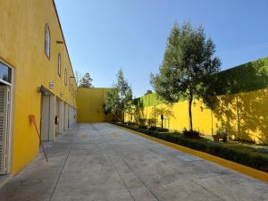 an empty sidewalk next to a yellow building at Hotel-Motel Calens in Velasco