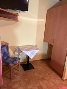 Zimmer mit einem Tisch, einem Stuhl und einem TV in der Unterkunft Apartement 2 Zur alten Press in Jennersdorf