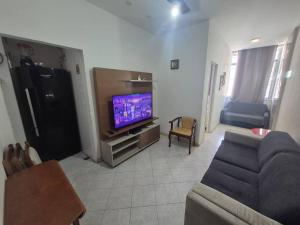 een woonkamer met een bank en een flatscreen-tv bij SUH Copacabana 143 in Rio de Janeiro