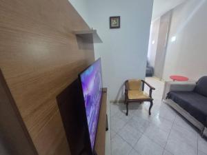 een woonkamer met een flatscreen-tv en een bank bij SUH Copacabana 143 in Rio de Janeiro