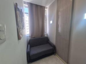 een trap met een stoel in een kamer met een raam bij SUH Copacabana 143 in Rio de Janeiro +2 foto's