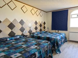 a room with two beds and a window at Hotel-Motel Calens in Velasco