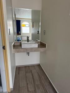 a bathroom with a sink and a mirror at Hotel-Motel Calens in Velasco