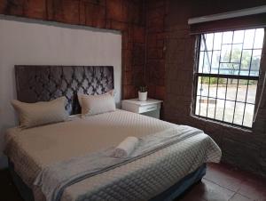 En eller flere senge i et værelse på Mboma Lodge