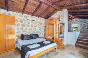 a bedroom with a bed and a stone wall at Villa Safi in İslâmlar +44 photos