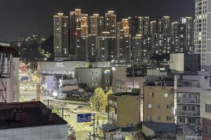 une vue nocturne d'une ville avec de hauts bâtiments dans l'établissement Stay Libera, à Gangneung
