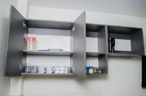 une cuisine avec des étagères noires sur un mur dans l'établissement Sunny Charm Studio Wi-fi & Netflix, à Nairobi 19 autres photos