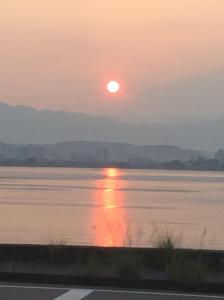 un coucher de soleil sur une étendue d'eau dans l'établissement Hotel Biwako Plaza, à Moriyama