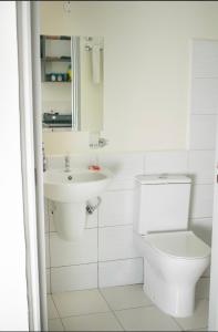 une salle de bains blanche avec toilettes et lavabo dans l'établissement Sunny Charm Studio Wi-fi & Netflix, à Nairobi