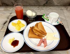 Ein Tablett mit zwei Tellern Essen, Toast und Pommes. in der Unterkunft Hotel Del Centro in Guayaquil