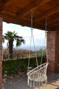 a white swing hanging from a porch with a palm tree at Peuta Hill in Podgorica