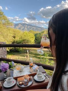 una donna seduta a un tavolo con un bicchiere di vino di Complejo Cabañas La Aguada a La Población