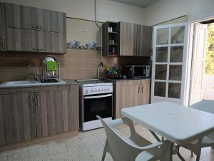 Una cocina con una mesa, un fregadero y una estufa. en Beautiful cozy house in Constantine with amazing views, en Constantina
