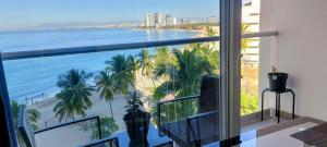 a balcony with a view of a beach and the ocean at Beachfront Harbor 171 Condo Ocean View Pool, Gym WiFi in Puerto Vallarta