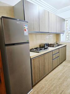 una nevera de acero inoxidable en una cocina con armarios de madera en Sunset Ocean View, en Rabat